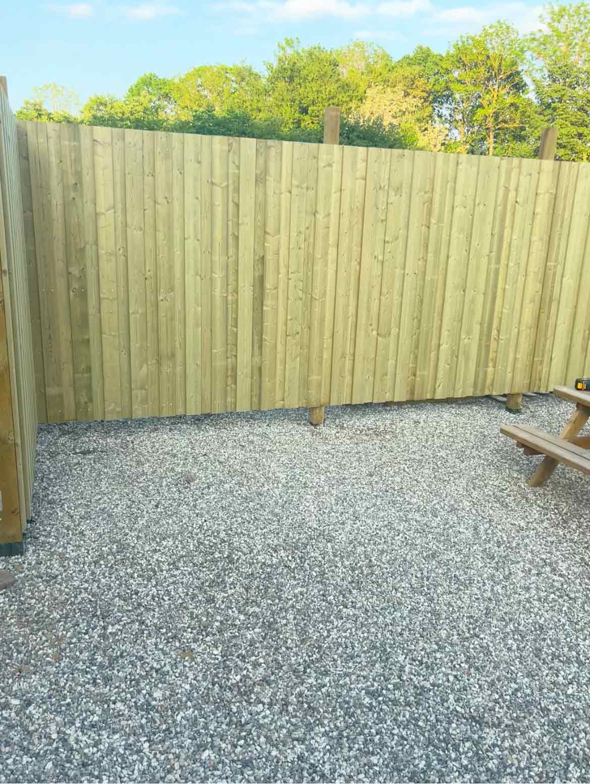 Færdigt hegn monteret af MogaByG, som nu tilbyder både funktionalitet og æstetik til gården.