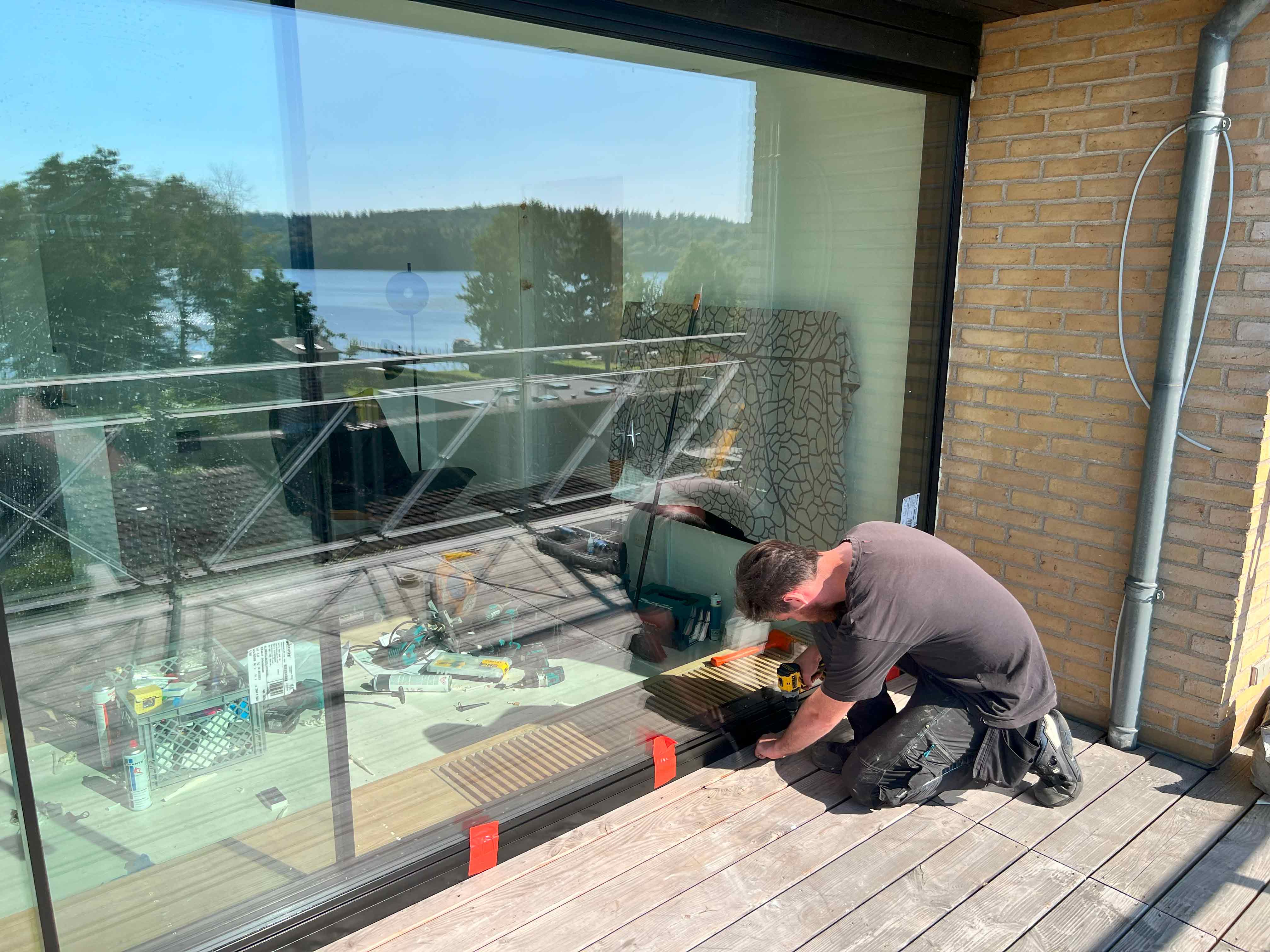 MogaByG foretager en grundig kontrol af den nyinstallerede skydedør og de store glasvinduer for optimal funktion.