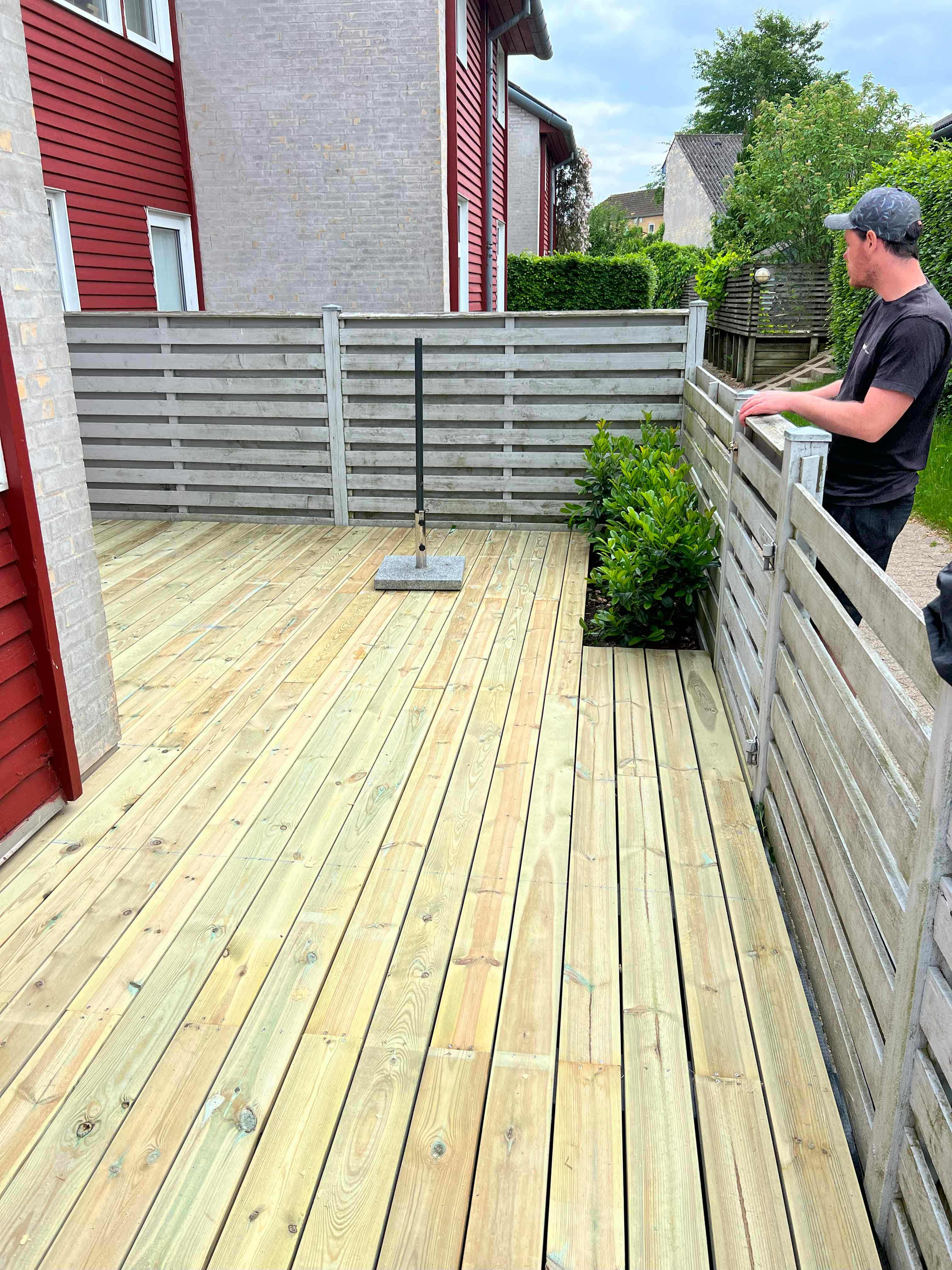 Den færdige terrasse står nu klar i haven, bygget af MogaByG for at skabe et perfekt udendørs rum.